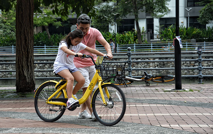 Father teaching child to ride a bike