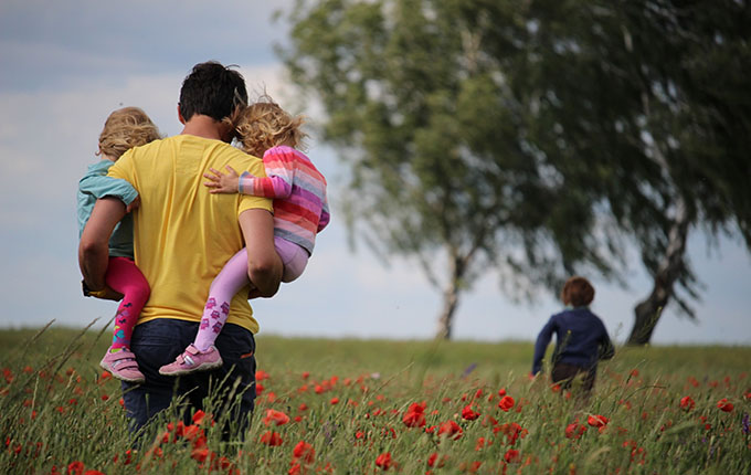 Vater und Kinder auf einer Wiese