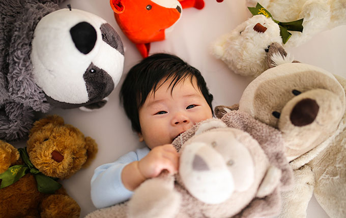 Baby mit Kuscheltieren