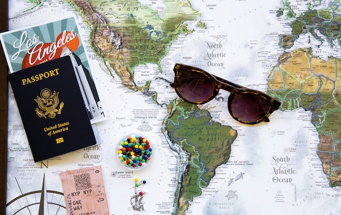 Karte mit Reisepass und Sonnenbrille darauf liegend