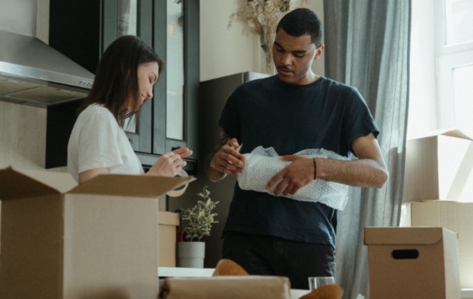 Man and woman packing with bubble wrap