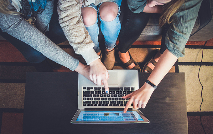 Three friends online shopping on a computer