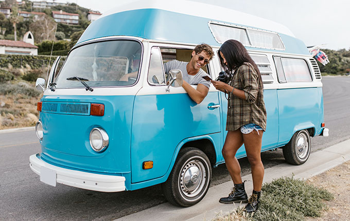 2 Adults by a Beach Bus