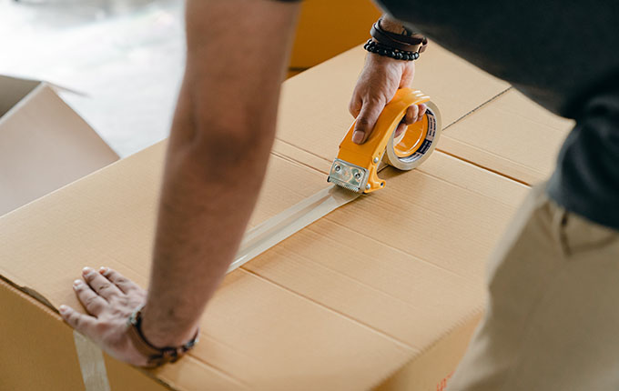 Hombre grabando una caja de cartón