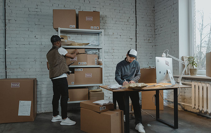 Hombres haciendo inventario con cajas de cartón.