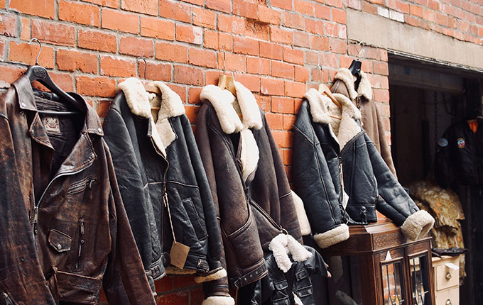 Chaquetas con adornos de piel de cuero colgado en una pared.