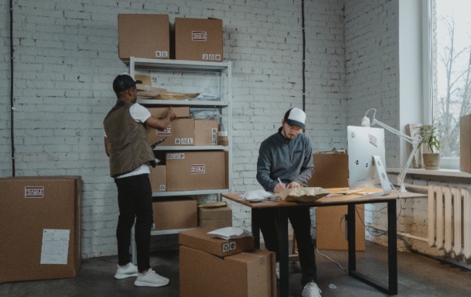 Hombres organizando cajas de cartón para su negocio.
