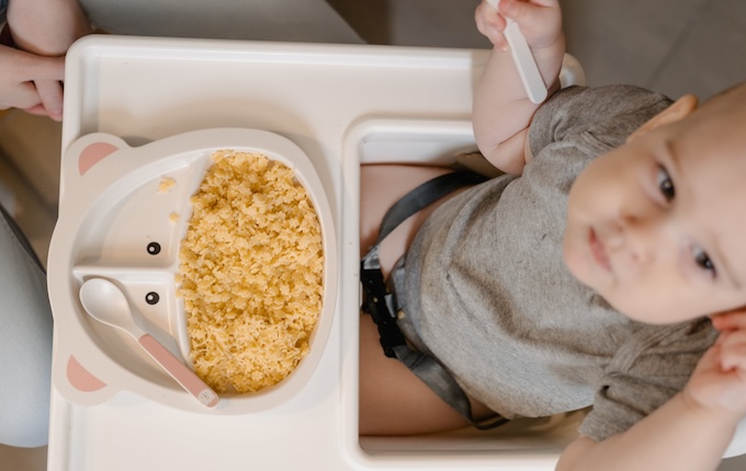 bébé assis sur une chaise haute en train de manger