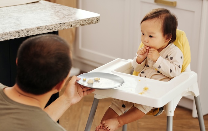 ハイチェアで食事をする赤ちゃん