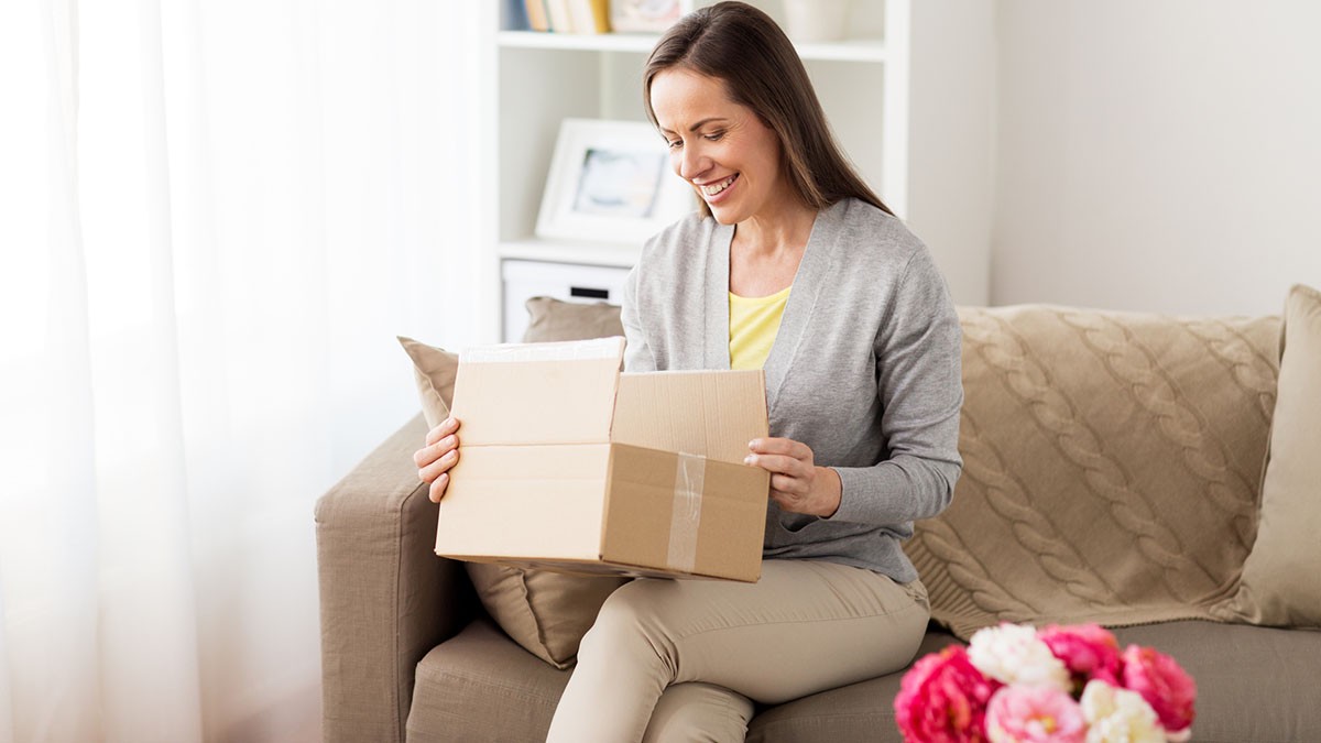 Evde paket açan mutlu alışverişçi